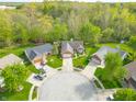 An aerial view of the brick home situated on a cul-de-sac with mature trees at 5615 Burning Tree Ct, Indianapolis, IN 46239