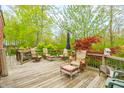 Expansive back deck with ample seating, an umbrella, and a view of the wooded yard at 5615 Burning Tree Ct, Indianapolis, IN 46239