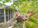 Enjoy outdoor living on this home's backyard deck with screened-in porch and mature trees providing shade at 5615 Burning Tree Ct, Indianapolis, IN 46239
