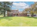 Beautiful two-story home with brick and vinyl siding, surrounded by lush landscaping and a spacious lawn at 5901 W Thompson Rd, Indianapolis, IN 46221