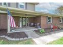 Inviting front porch with decorative seating and seasonal decor, plus a view of the landscaped front yard at 5901 W Thompson Rd, Indianapolis, IN 46221