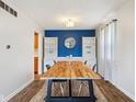 Bright dining room featuring hardwood floors, built-in shelving, and a modern light fixture at 6123 W 46Th St, Indianapolis, IN 46254