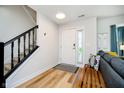 Bright foyer featuring hardwood floors, stairs with black wood railing and a white front door at 6144 Black Oaks Way, Indianapolis, IN 46237