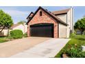 Exterior view of brick facade with a two-car garage and a well-kept lawn at 6144 Black Oaks Way, Indianapolis, IN 46237