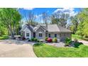 Well-manicured lawn surrounds this beautiful brick home with inviting landscaping and stone accents at 6149 W Olive Branch Rd, Greenwood, IN 46143