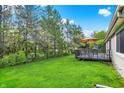 Well-maintained backyard features a lush lawn and a spacious deck, creating a serene and inviting outdoor oasis at 6257 Old Barn Ct, Indianapolis, IN 46268