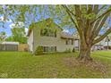 A well-manicured lawn surrounds this cozy two-story home, shaded by a large tree in the front yard at 6638 Sunbury Dr, Indianapolis, IN 46241