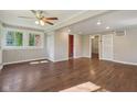 Spacious living room with hardwood floors, a ceiling fan and natural light through multiple windows at 7002 N Ralston Ave, Indianapolis, IN 46220