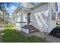 Inviting home entrance with freshly painted stairs and trim and manicured lawn at 717 S A St, Elwood, IN 46036