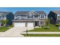 Charming two-story home with a three car garage, manicured lawn, and professional landscaping at 900 Parker Ln, Westfield, IN 46074