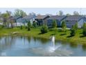 Picturesque view of a pond with a fountain, surrounded by well-maintained lawns and community homes at 900 Parker Ln, Westfield, IN 46074