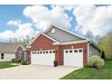 Brick and gray home with a two-car garage and meticulously maintained landscaping at 9359 Foudray N Cir, Avon, IN 46123