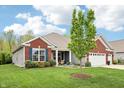 Well-kept brick and gray house featuring a manicured lawn and inviting front porch at 9359 Foudray N Cir, Avon, IN 46123