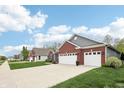 Street view of homes with brick and gray exteriors and well-manicured lawns at 9359 Foudray N Cir, Avon, IN 46123