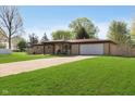 Attractive single-Gathering home with a manicured lawn, inviting entrance, and an attached garage with ample parking at 9748 W Sunset Ln, Elwood, IN 46036