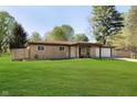 Beautiful one-story home boasting a well-maintained front yard, mature trees, and attached two-car garage at 9748 W Sunset Ln, Elwood, IN 46036