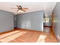 Spacious living room with laminate wood flooring, a ceiling fan, and natural light at 112 Coronado Rd, Indianapolis, IN 46234