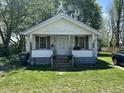 Charming one-story home with a covered porch, front lawn, and mature trees at 1221 E 22Nd St, Anderson, IN 46016