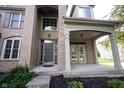 Covered front porch and entryway featuring brick facade and well-maintained landscaping at 12493 Loudoun Pl, Fishers, IN 46037