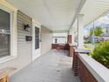 Inviting covered front porch with brick pillars, seating area and outdoor lighting fixture at 1408 W Jackson St, Muncie, IN 47303
