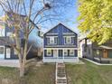 Inviting two-story home with a covered porch and mature trees in a desirable neighborhood at 1417 E Michigan St, Indianapolis, IN 46201