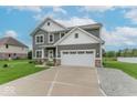 Attractive two-story home showcasing gray siding, a two-car garage, and an expansive driveway at 1417 Layton Rd, Anderson, IN 46011