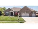 Lovely brick home with a two-car garage and meticulously maintained front yard and garden at 1426 Manchester Dr, Danville, IN 46122