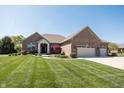 Charming brick home with a manicured lawn, stone accents and a two-car garage at 1426 Manchester Dr, Danville, IN 46122
