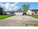 Well-maintained home with an attached garage and large driveway, perfect for multiple vehicles at 155 Suncrest Dr, Greenwood, IN 46143