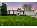 Charming single-story home featuring a well-manicured lawn, attached garage, and inviting front porch at 155 Suncrest Dr, Greenwood, IN 46143