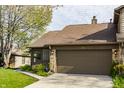 Attractive townhouse with a two-car garage, complemented by lush greenery at 2236 Calaveras Way, Indianapolis, IN 46240