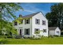 Attractive two-story home with well-manicured lawn and detached garage, set against a blue sky at 2405 Sycamore St, Columbus, IN 47201