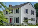 Beautiful two-story home with white siding, green shutters, and a vibrant red front door at 2405 Sycamore St, Columbus, IN 47201