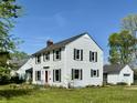 Traditional two-story home featuring white siding, green shutters, and a well-maintained lawn and an adjacent detached garage at 2405 Sycamore St, Columbus, IN 47201