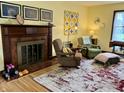 Cozy living room with a fireplace, area rug, hardwood floors, and ample seating, creating a warm and inviting space at 2405 Sycamore St, Columbus, IN 47201