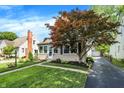 Cozy one-story home with manicured lawn, brick chimney, and an inviting driveway at 2512 E 57Th St, Indianapolis, IN 46220