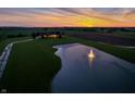 Expansive aerial view of the estate showcasing the pond with a fountain and lush green lawn at sunset at 2575 W 100 S, Franklin, IN 46131