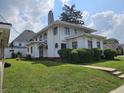 Charming two-story home with a well-maintained lawn and mature trees at 302 E Main St, Greenfield, IN 46140