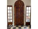 A solid wood front door flanked by sidelights over black and white checkerboard flooring at 302 E Main St, Greenfield, IN 46140
