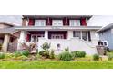 Inviting two-story home with a brick foundation, front porch, and verdant landscaping at 319 N Ridgeview Dr, Indianapolis, IN 46219