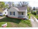 Single story home boasts a welcoming front porch and is surrounded by lush greenery at 3511 N Keystone Ave, Indianapolis, IN 46218