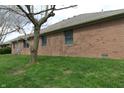 A brick house exterior showing the side of the home with multiple windows and green grass at 4652 Kensington N Way, Plainfield, IN 46168