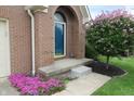 Close up of the blue front door entrance with a beautiful flowering tree and lovely pink flower bed at 4652 Kensington N Way, Plainfield, IN 46168