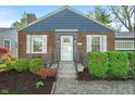 Close-up of a classic brick home with a tidy front yard and a welcoming white front door at 5504 Indianola Ave, Indianapolis, IN 46220