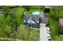 Aerial view of a home with a well-manicured lawn, an in-ground pool, trampoline and cars in the driveway at 562 Covered Bridge Rd, Greenwood, IN 46142