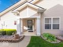 Inviting covered porch with decorative plants, stone landscaping, and charming entrance at 6146 Franklin Villas Way, Indianapolis, IN 46237