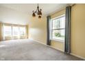 Bright living room boasts large windows, neutral carpet, and stylish chandelier at 6472 Creekshore Ln, Indianapolis, IN 46268