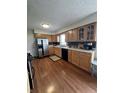 Functional kitchen with stainless steel appliances, wood cabinets, and a modern backsplash at 762 N Dellasburg Rd, Columbus, IN 47203
