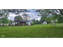 Beautiful home with a well-maintained yard, fence, and shed at 7639 N Frontage Rd, Fairland, IN 46126