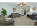 Spacious living room with comfortable seating, ceiling fan, and adjacent staircase at 7926 White Pine Dr, Avon, IN 46123